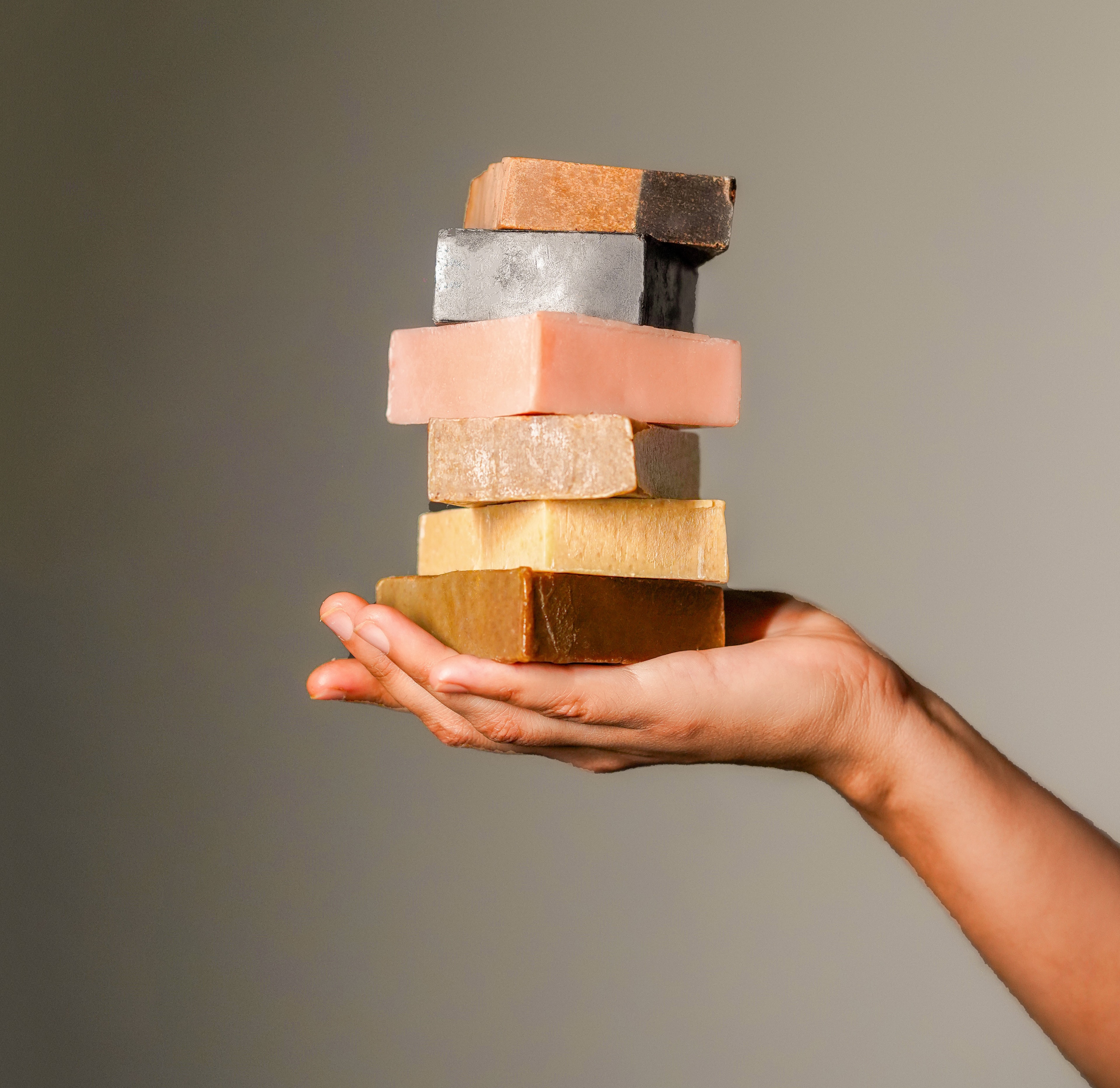 A hand presenting a stack of handmade bars